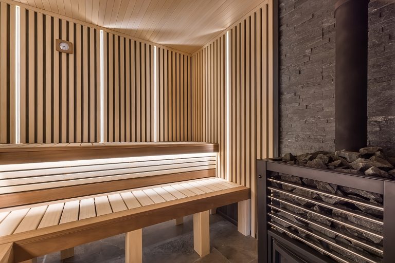 Modern wooden sauna interior with elegant lighting and electric heater