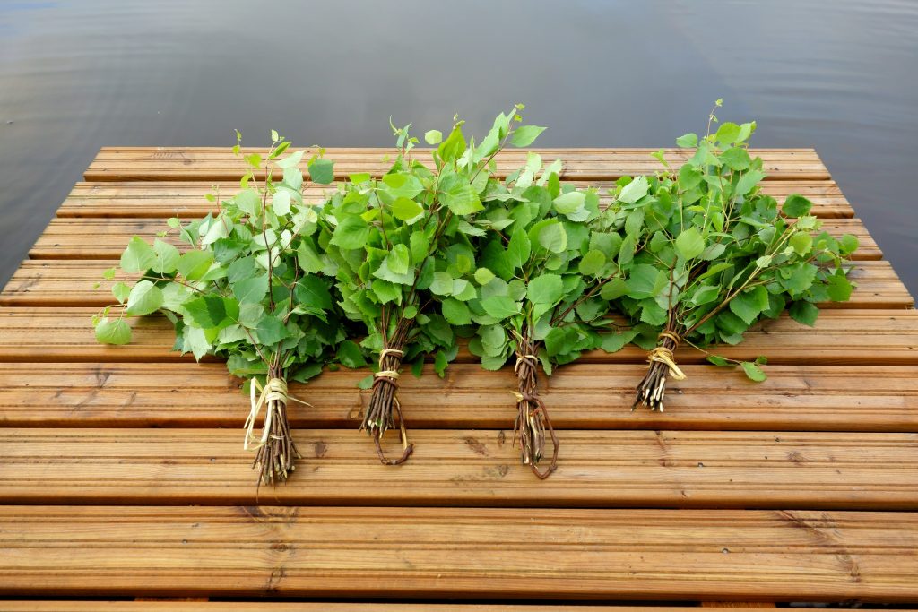 Traditional Finnish bath whisks on a jetty by the lake